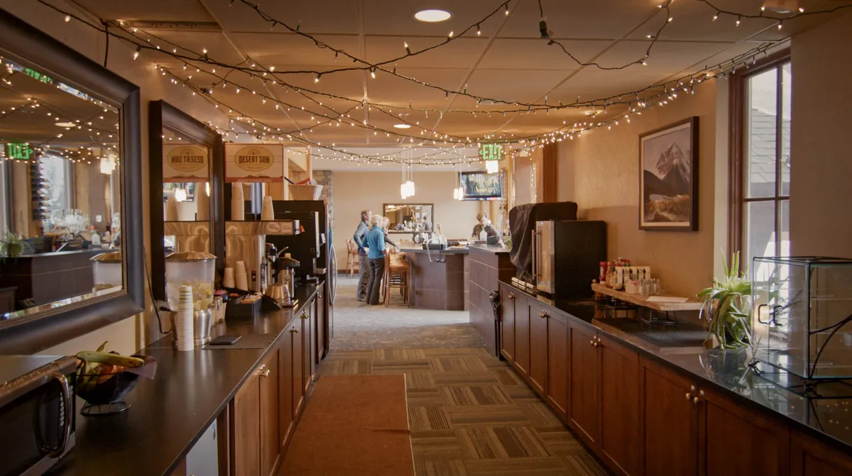 A stylish lounge with a coffee station, bar area, decorative lighting, and comfortable seating. The atmosphere is welcoming, ideal for socializing and unwinding with family or friends after a day of adventure.